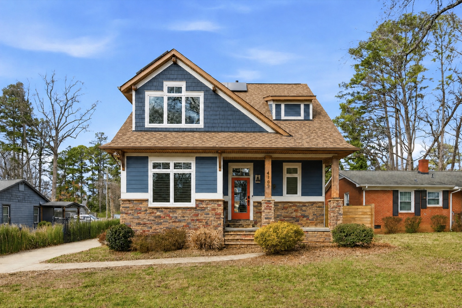 A blue craftsman two-story home managed by Blue Sky Village on a bright Carolina day