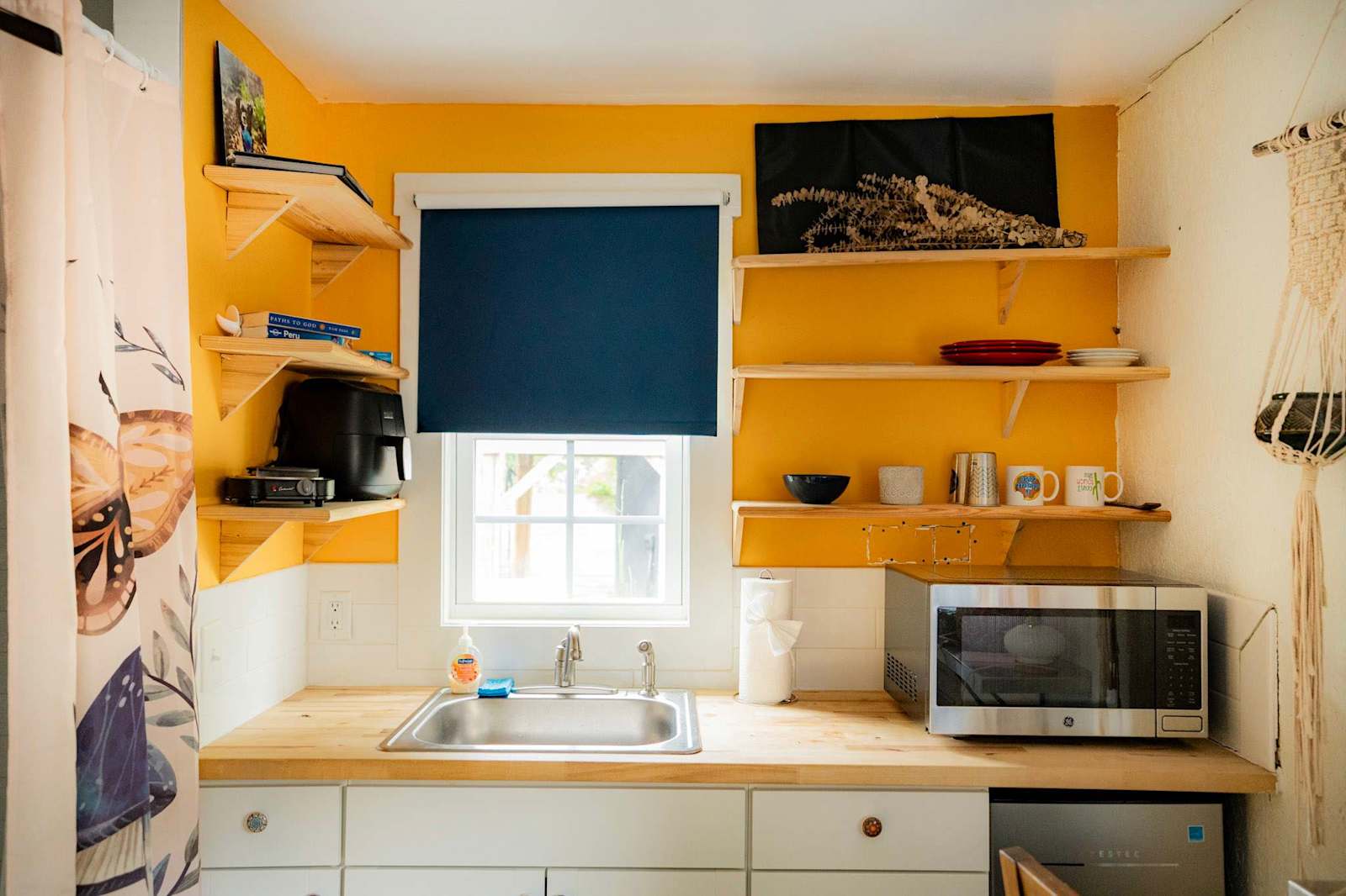 A sunlit kitchen with open shelving in a managed home